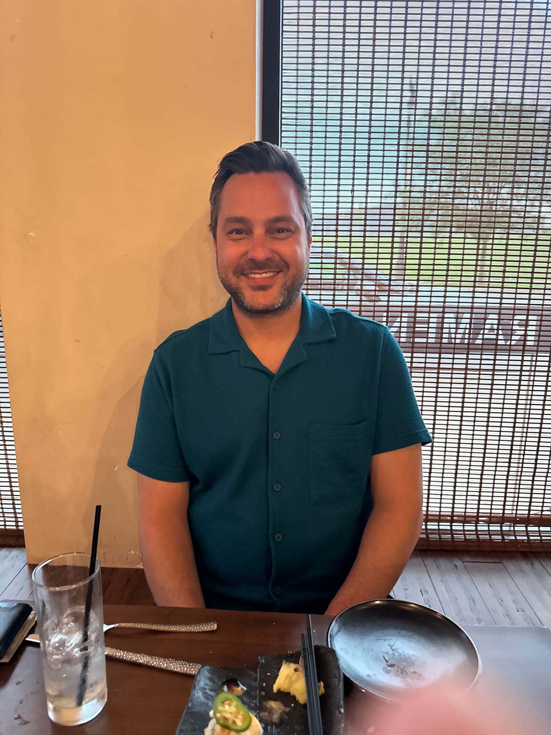 Justin Shahani smiling at a restaurant table