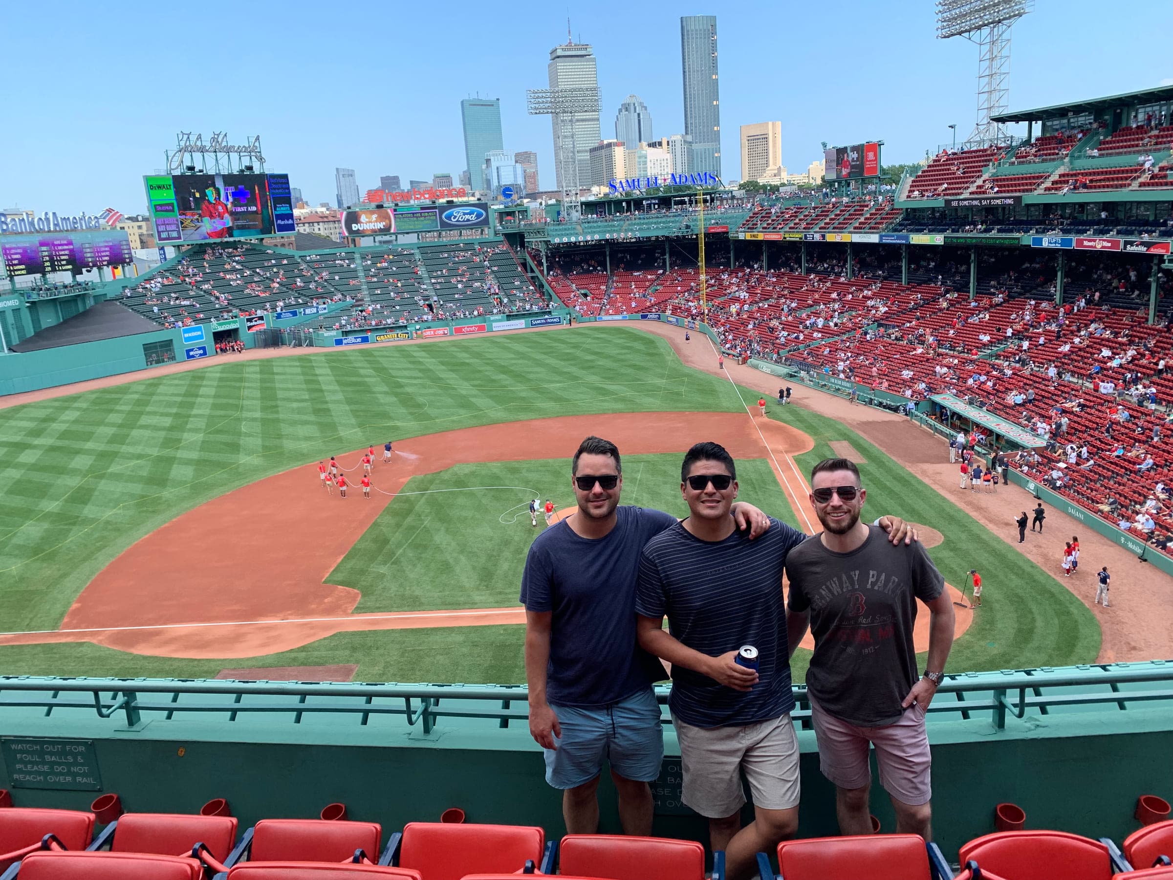 Justin with two friends at a baseball stadium