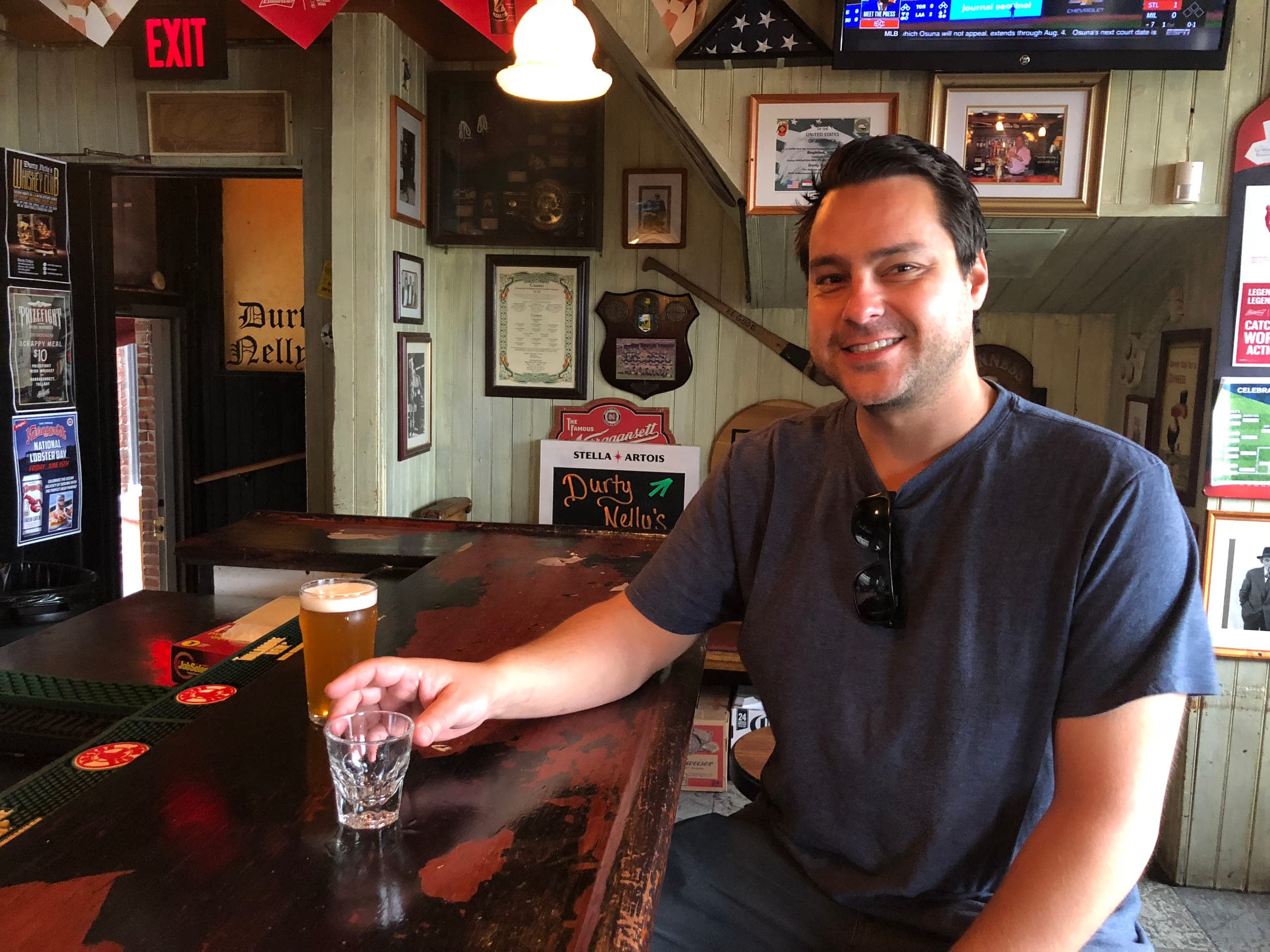 Justin leaning on a bar with a beer