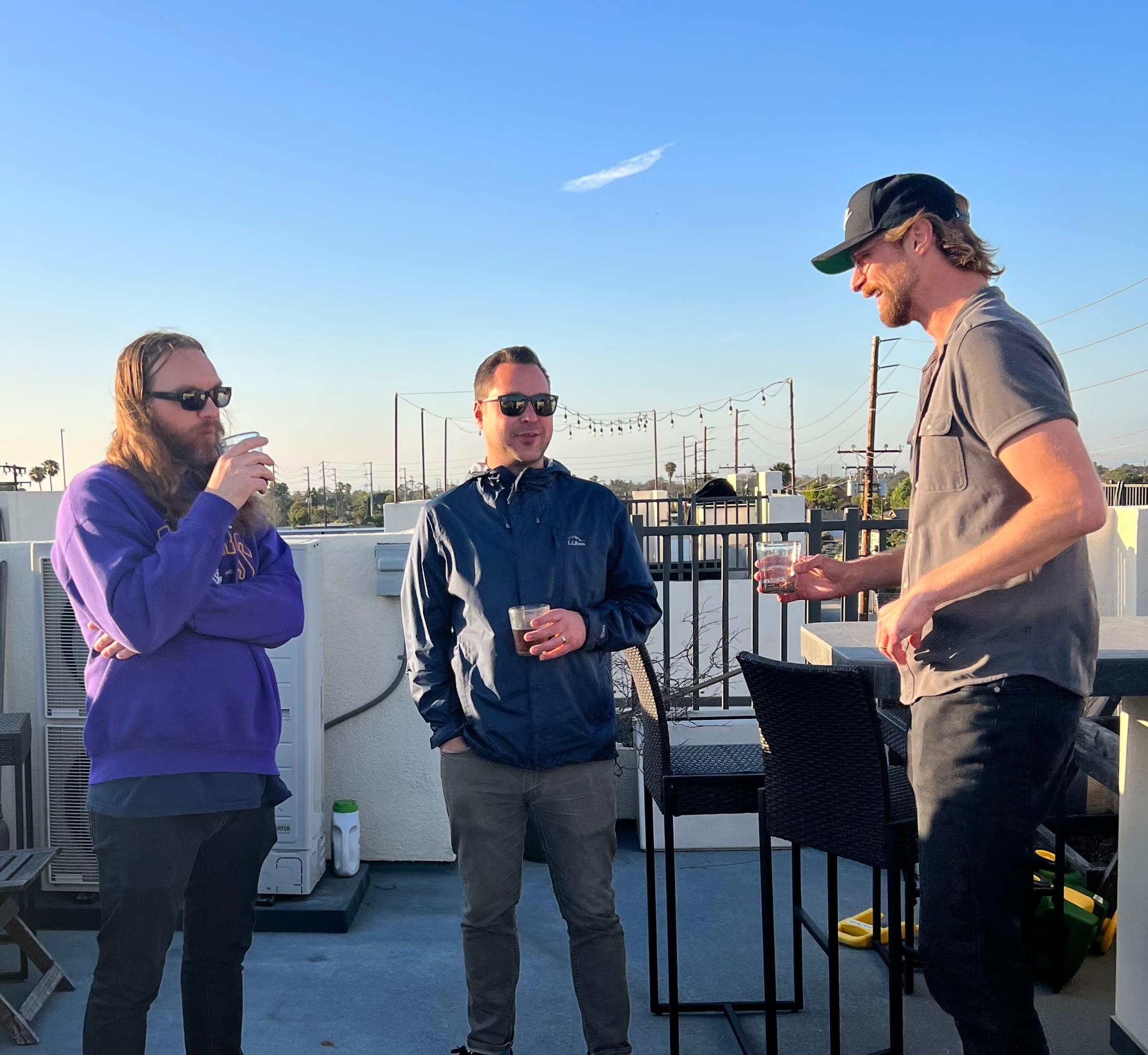 Justin with friends on a rooftop at sunset