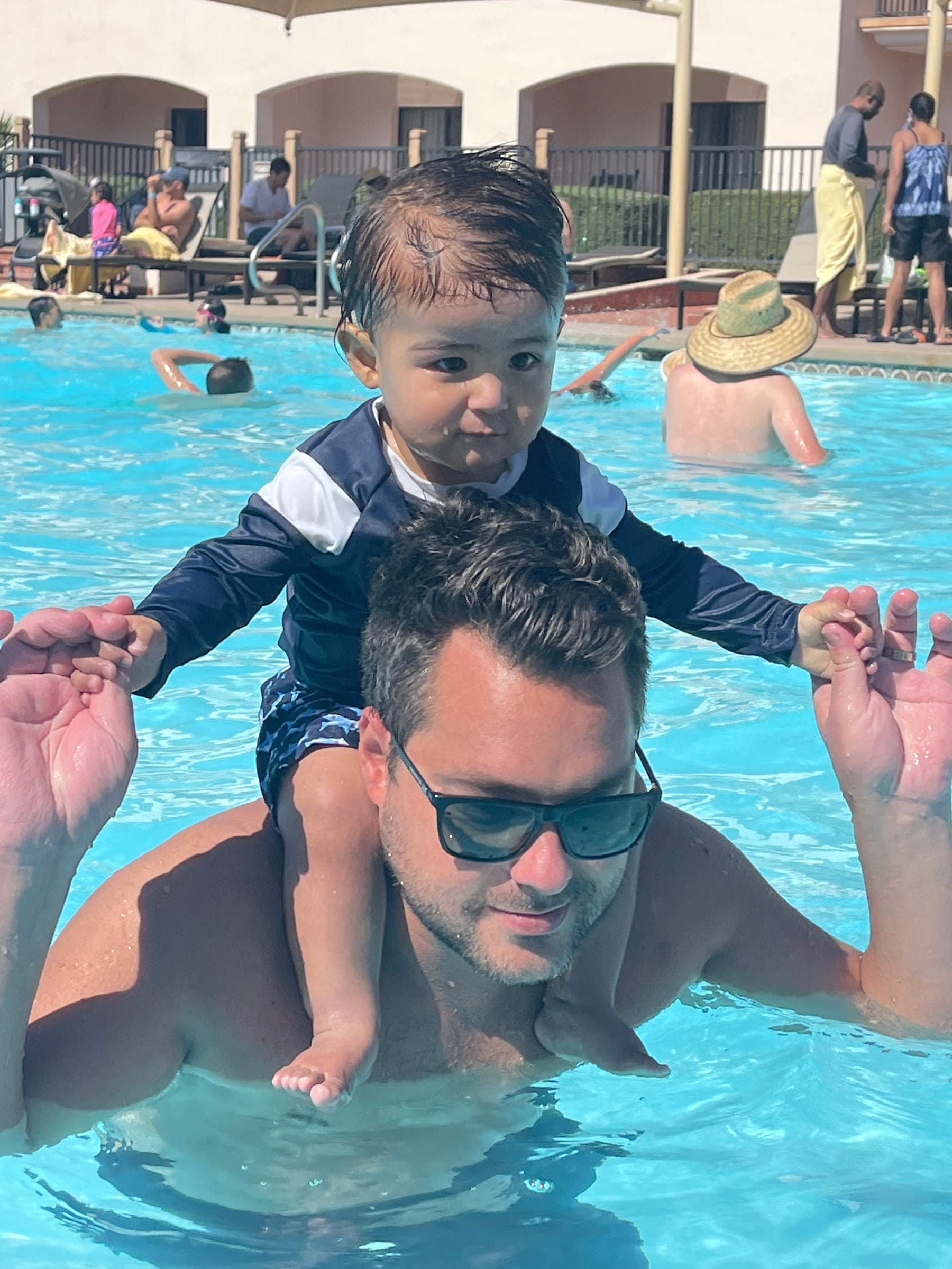 Justin in a pool with a small boy on his shoulders